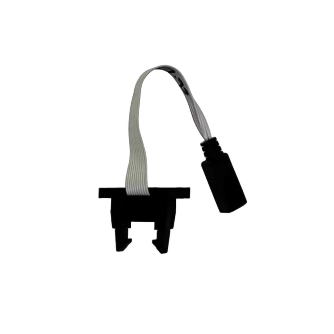 Black plastic component with a ribbon cable on a light gray background